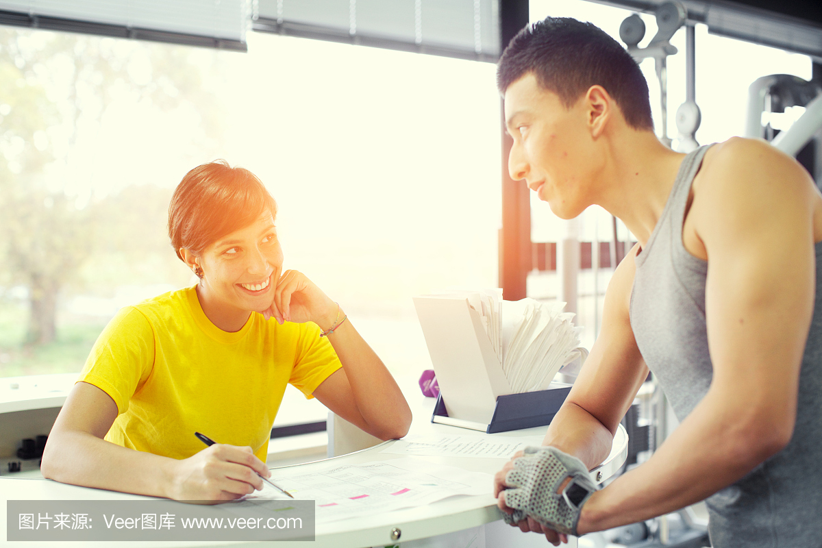 夫妇在健身房讨论训练计划