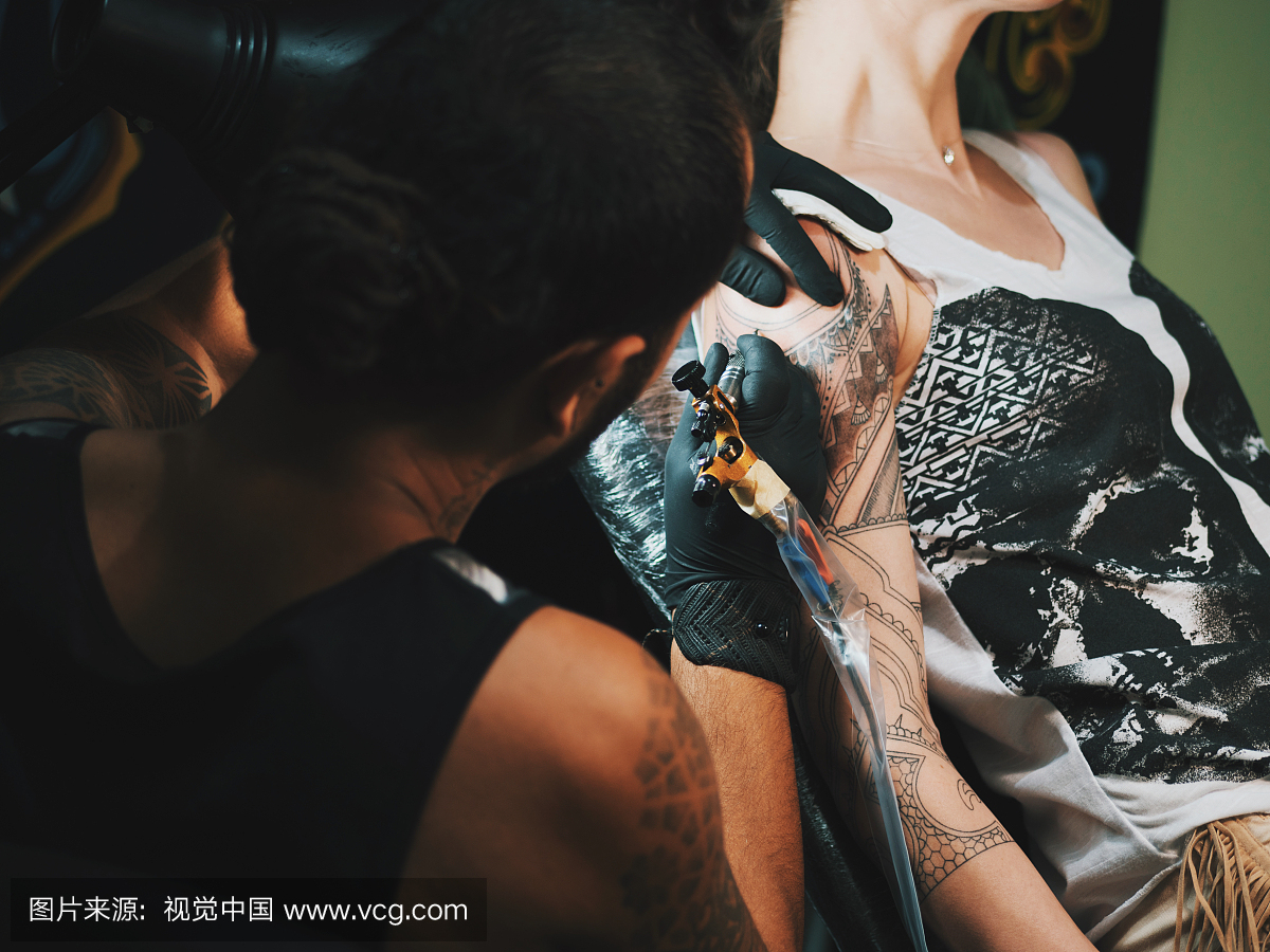 女性客户手上的纹身艺术家制作纹身