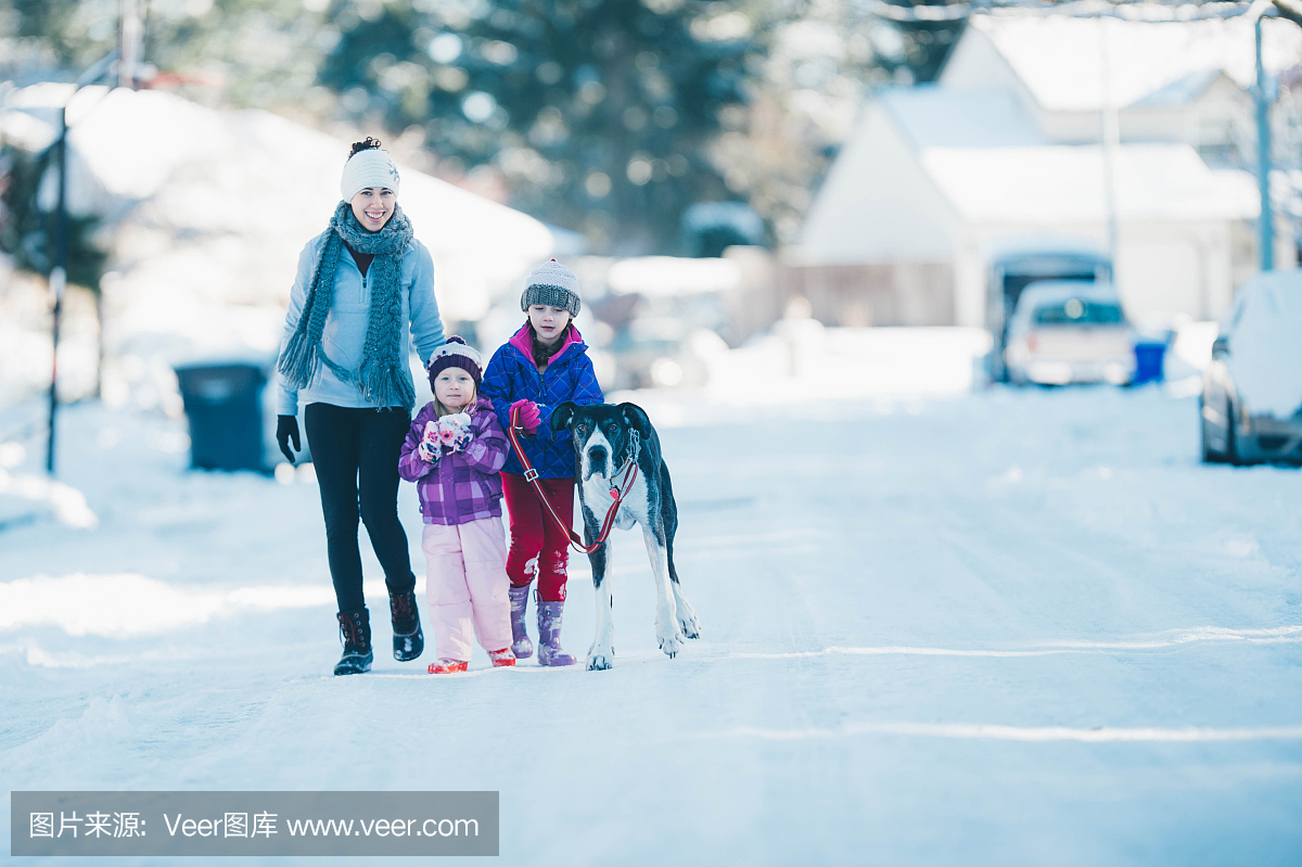 妈妈玩雪的邻居街上的年轻女孩