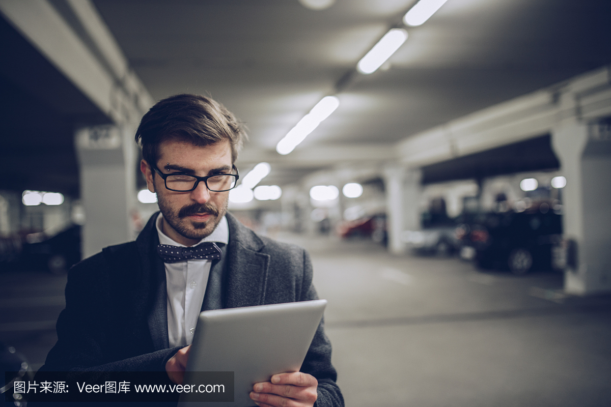 在停车场使用平板电脑的商人