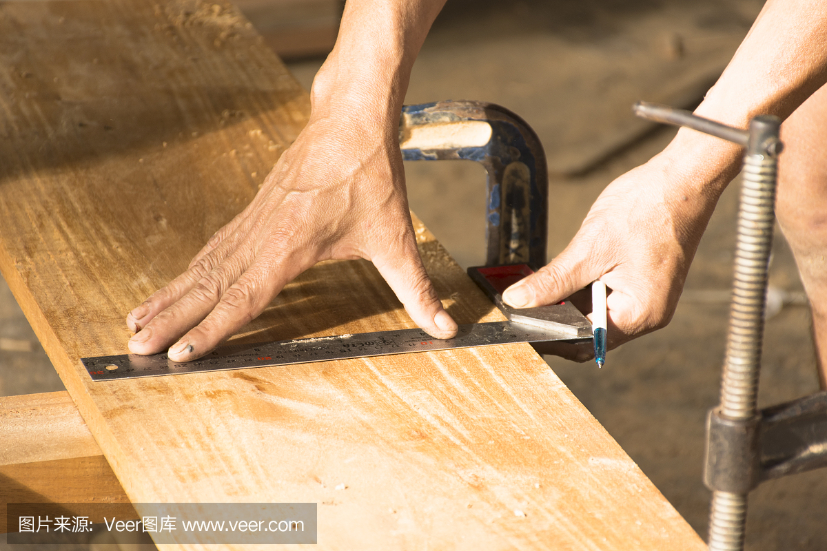 木匠工作在测量棒和工作计划。