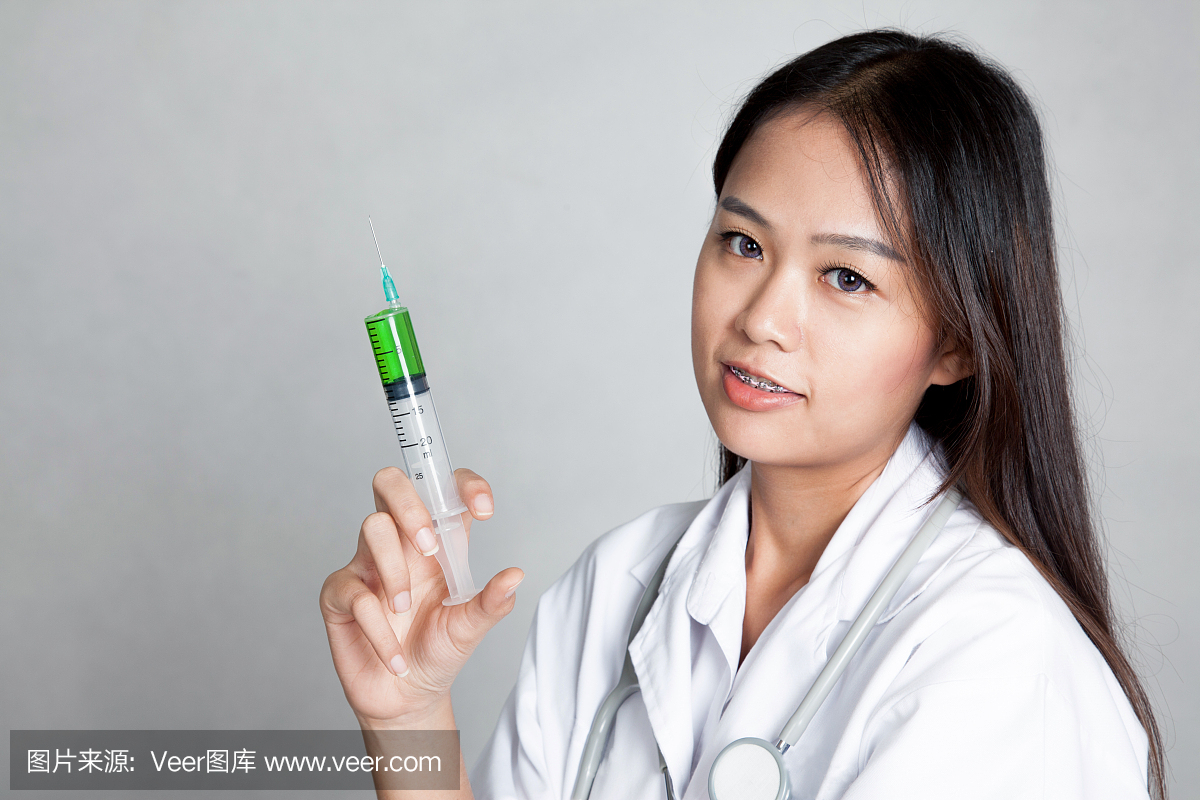年轻的亚洲女医生用注射器
