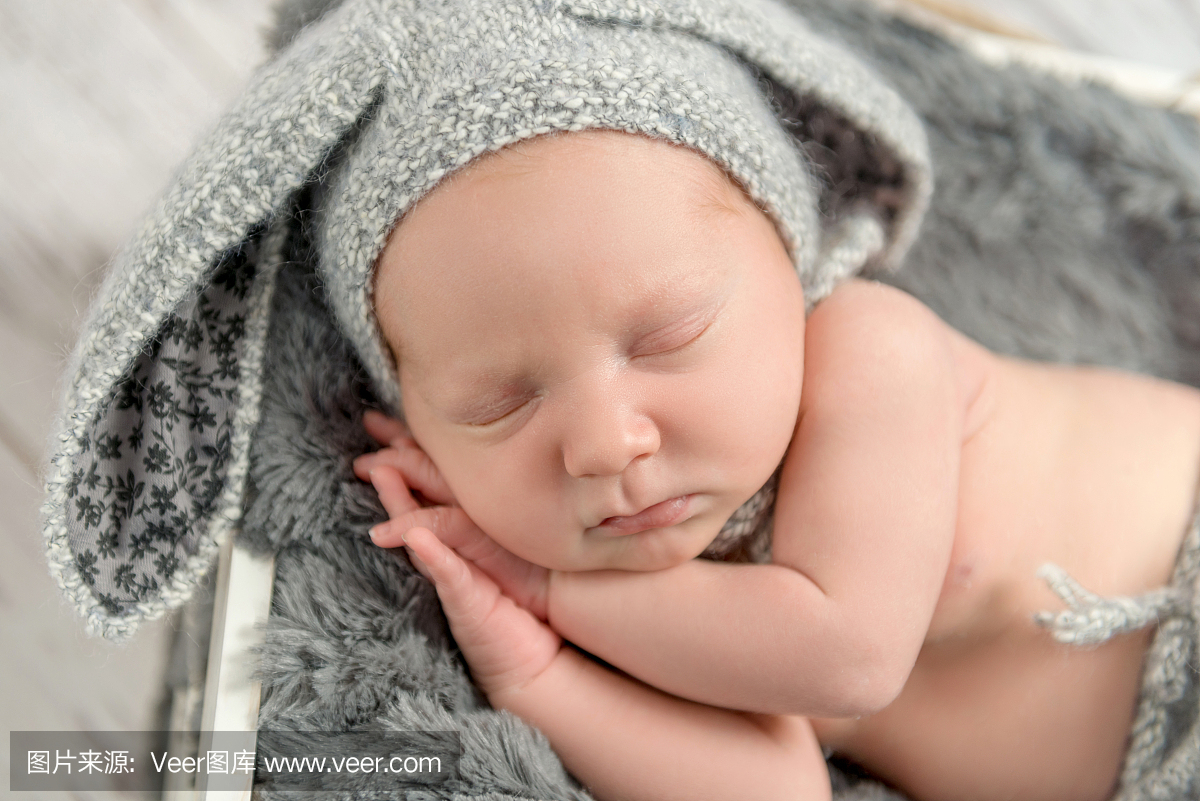 睡觉的婴儿在灰色的内裤和帽子与野兔耳朵
