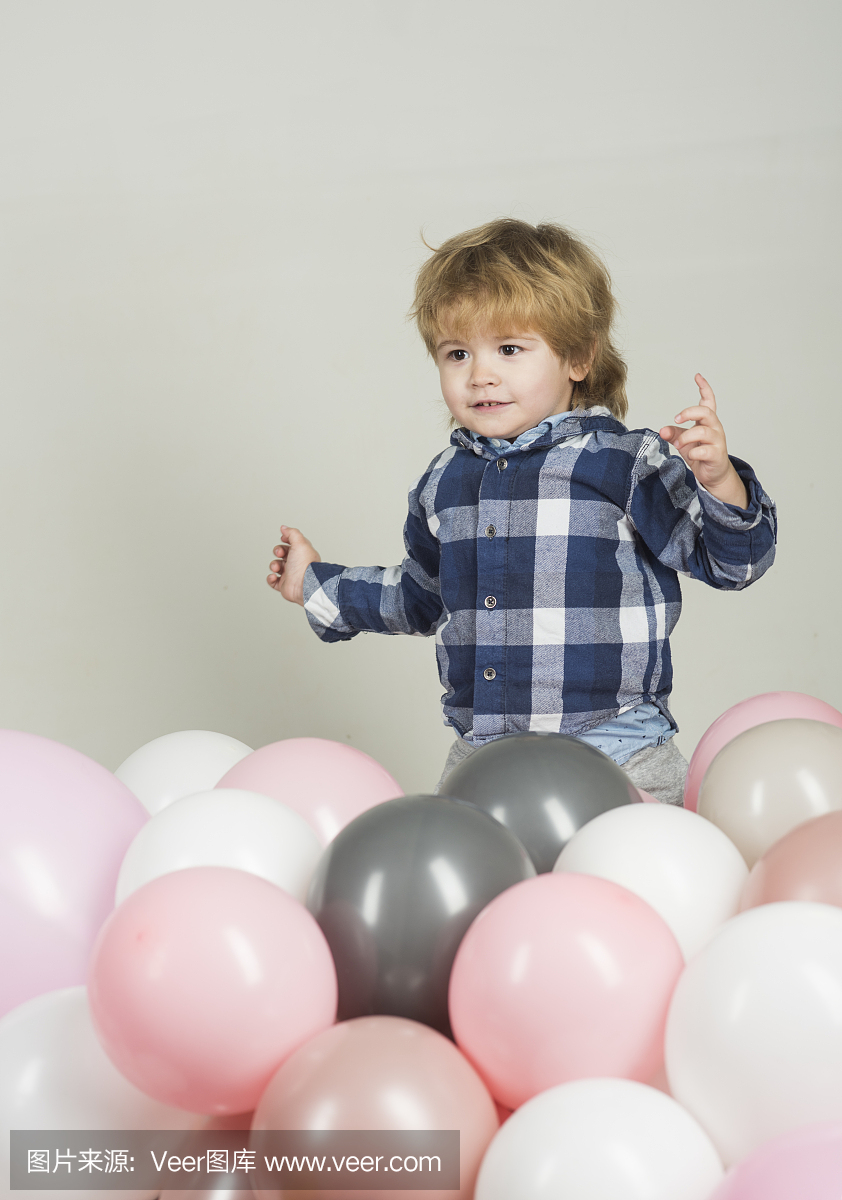 小男孩跳进粉红色的气球。有趣的孩子玩他自己