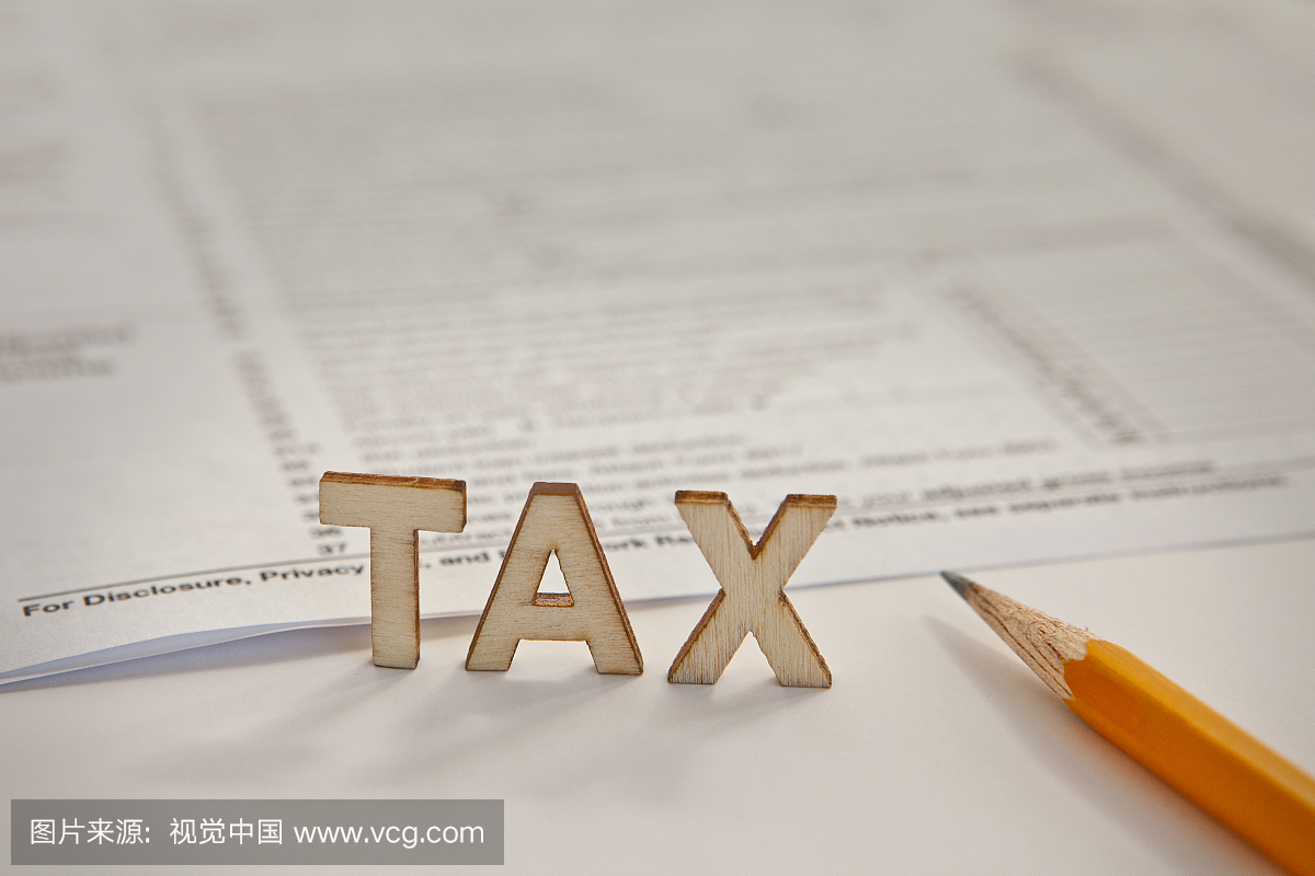 税务表格,铅笔和'TAX'以块字母表示