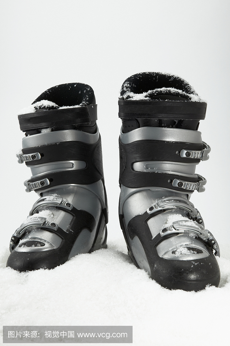 Detail view of a pair of ski boots in the snow