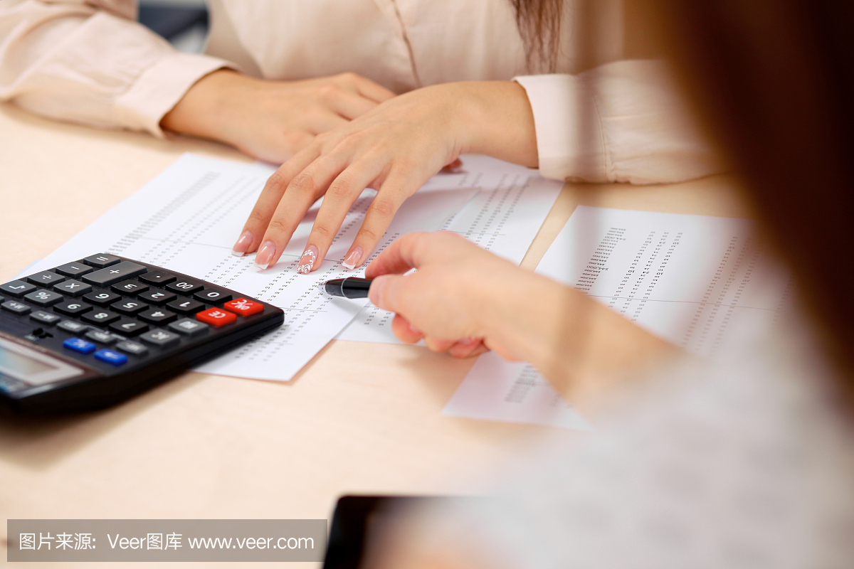 两名女性会计师指望计算器收入纳税表完成手特