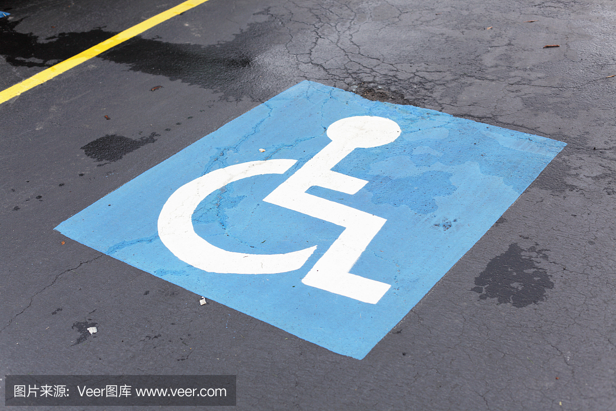 残酷的轮椅符号在一个肮脏的,破裂的停车位