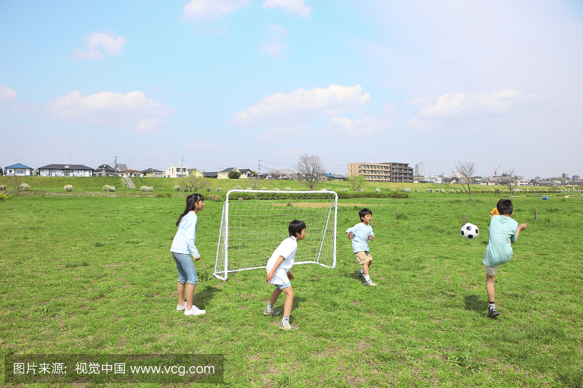四个孩子在球门附近踢足球。日本东京都的内谷