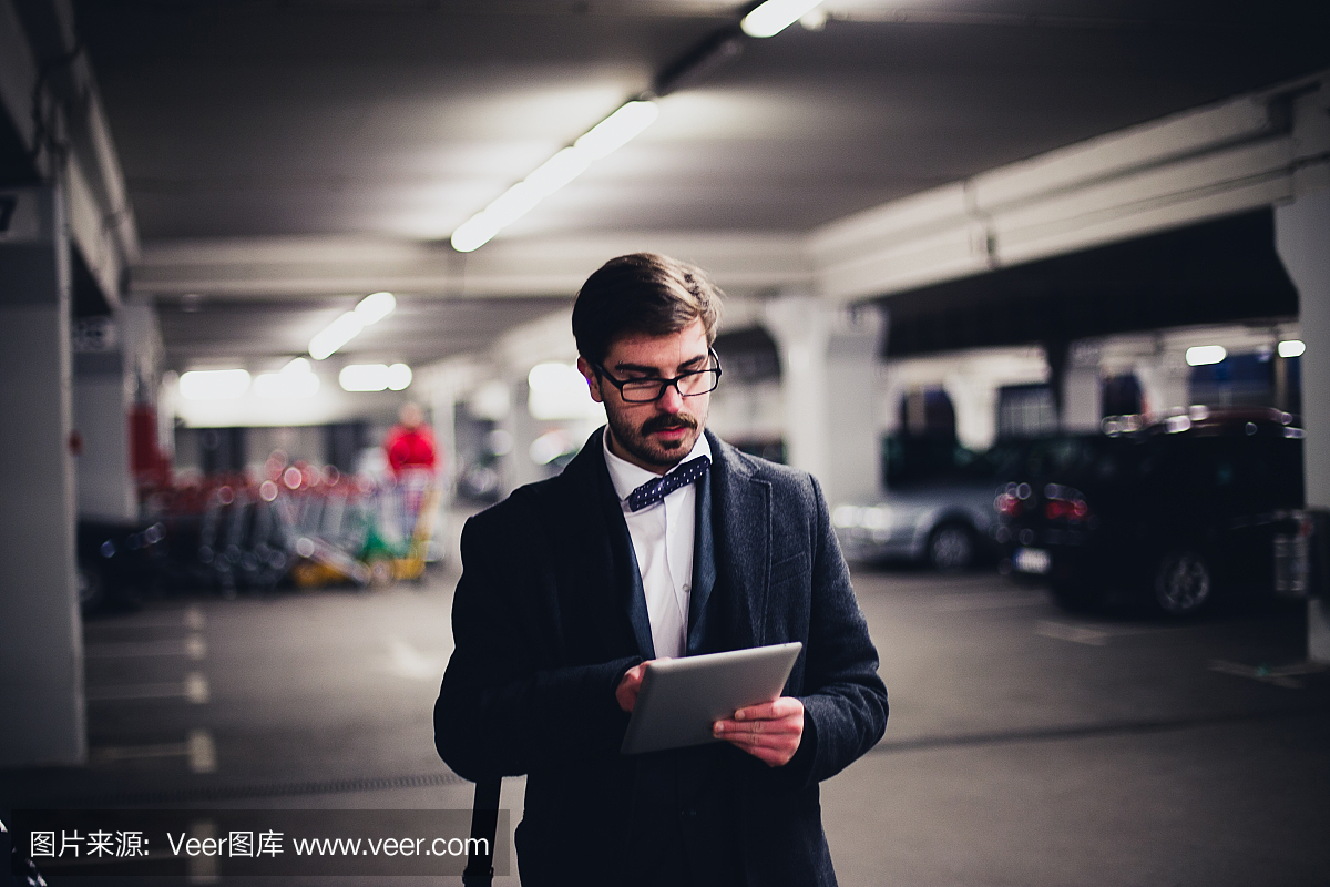 人走在停车场和使用平板电脑