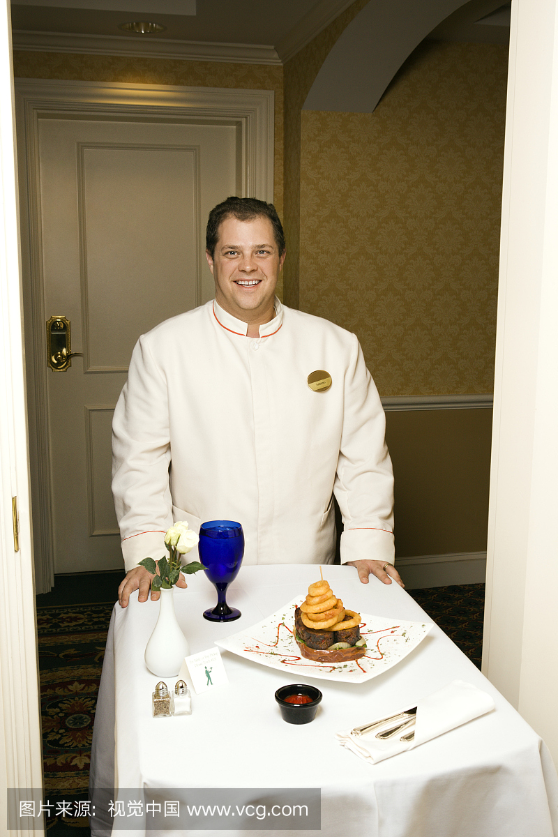 酒店客房服务员与走廊里的食物托盘