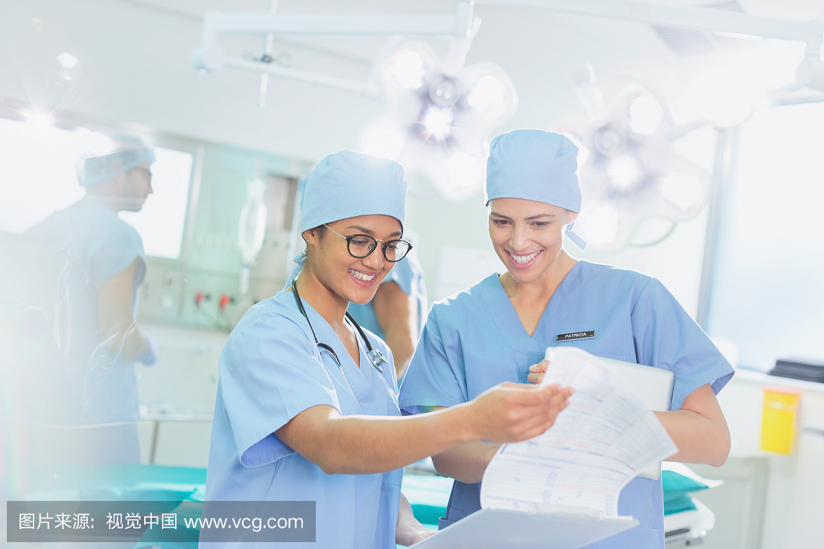 Female surgeons reviewing paperwork in oper