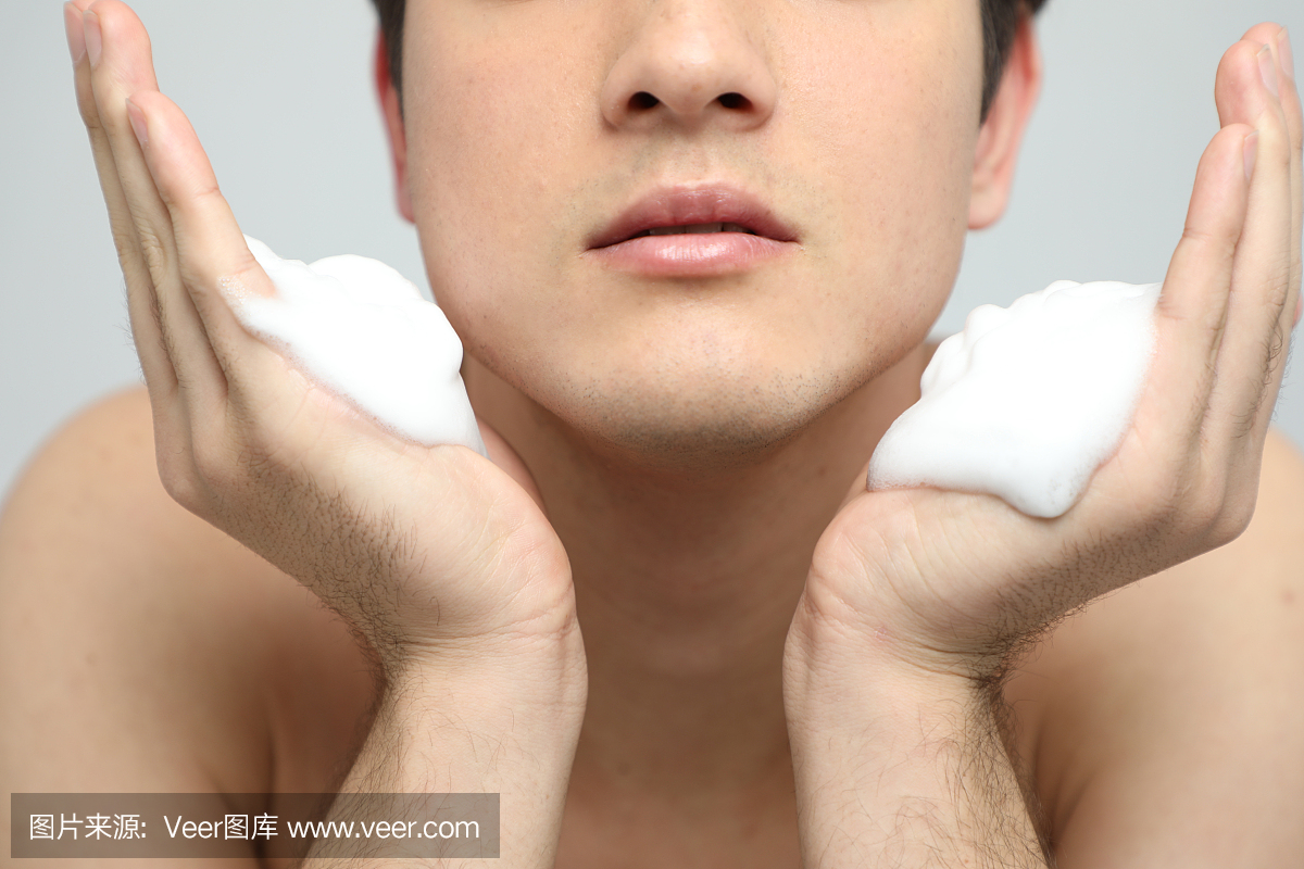 年轻人用清洁泡沫洗脸,男士护肤概念,痤疮治疗