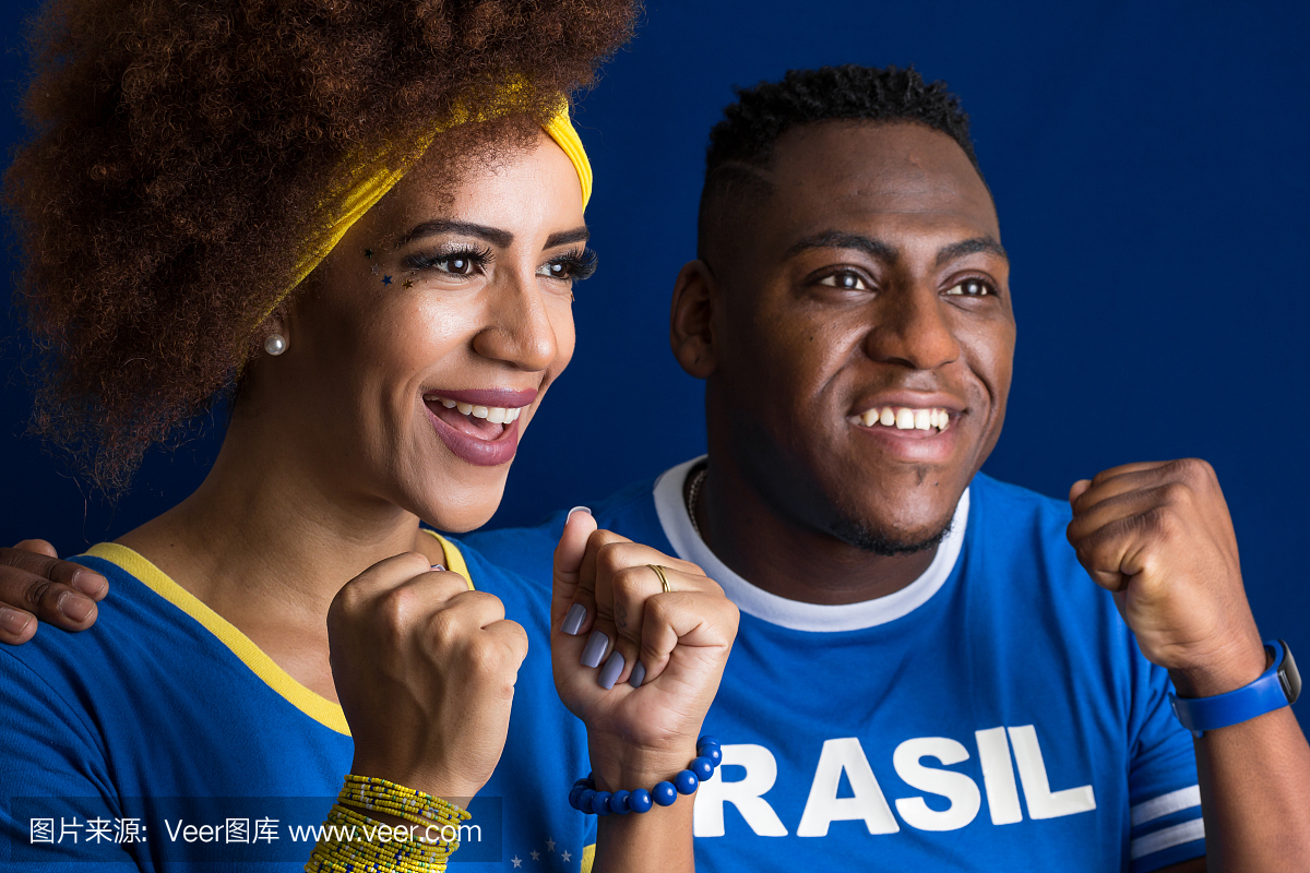 巴西夫妇球迷庆祝在蓝色背景上的足球比赛。巴