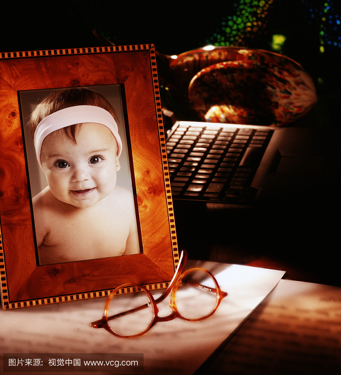 婴儿女孩(9-12个月)在桌子上的框架照片