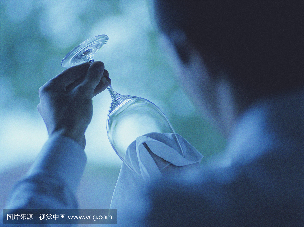 年轻男服务员清酒酒杯(专注于玻璃),后视