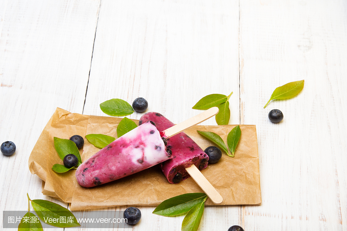 美味的自制蓝莓冰淇淋在白色的木制背景上。有