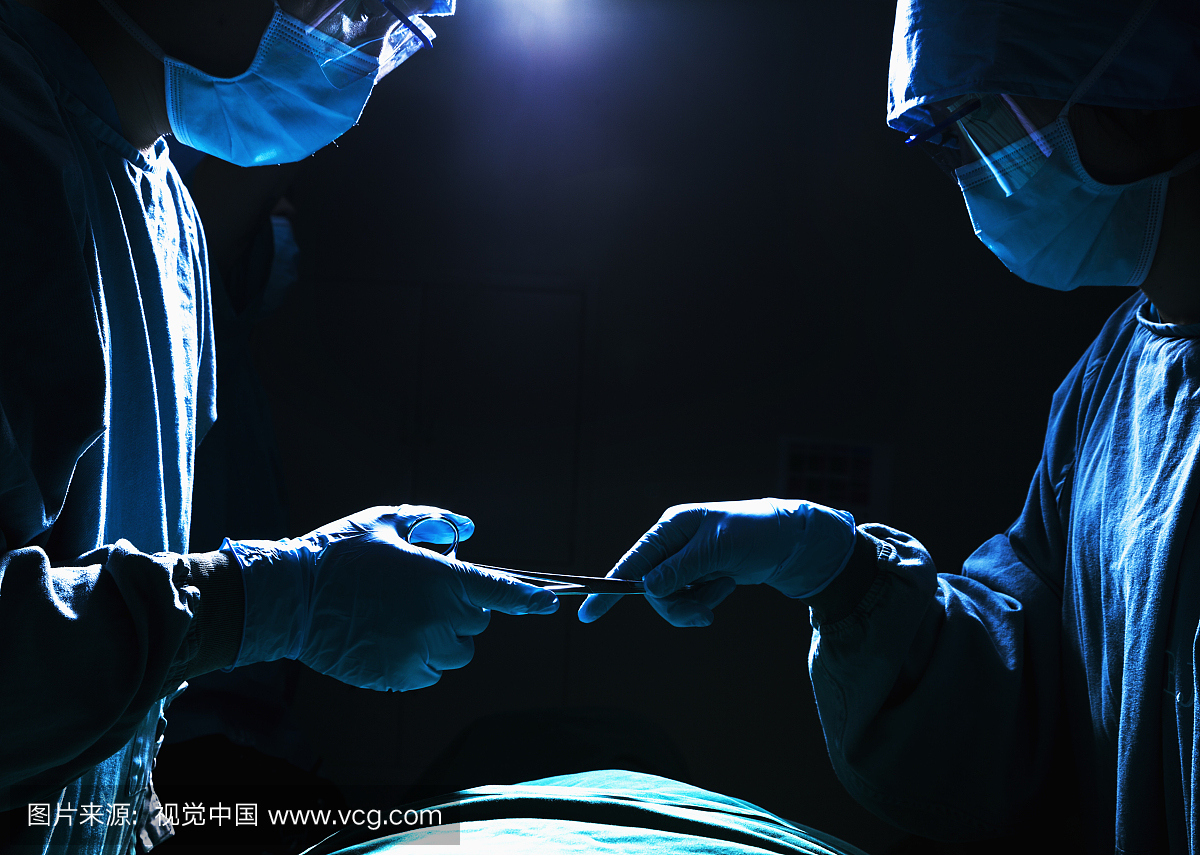 两名外科医生在手术室工作和通过手术器械,阴