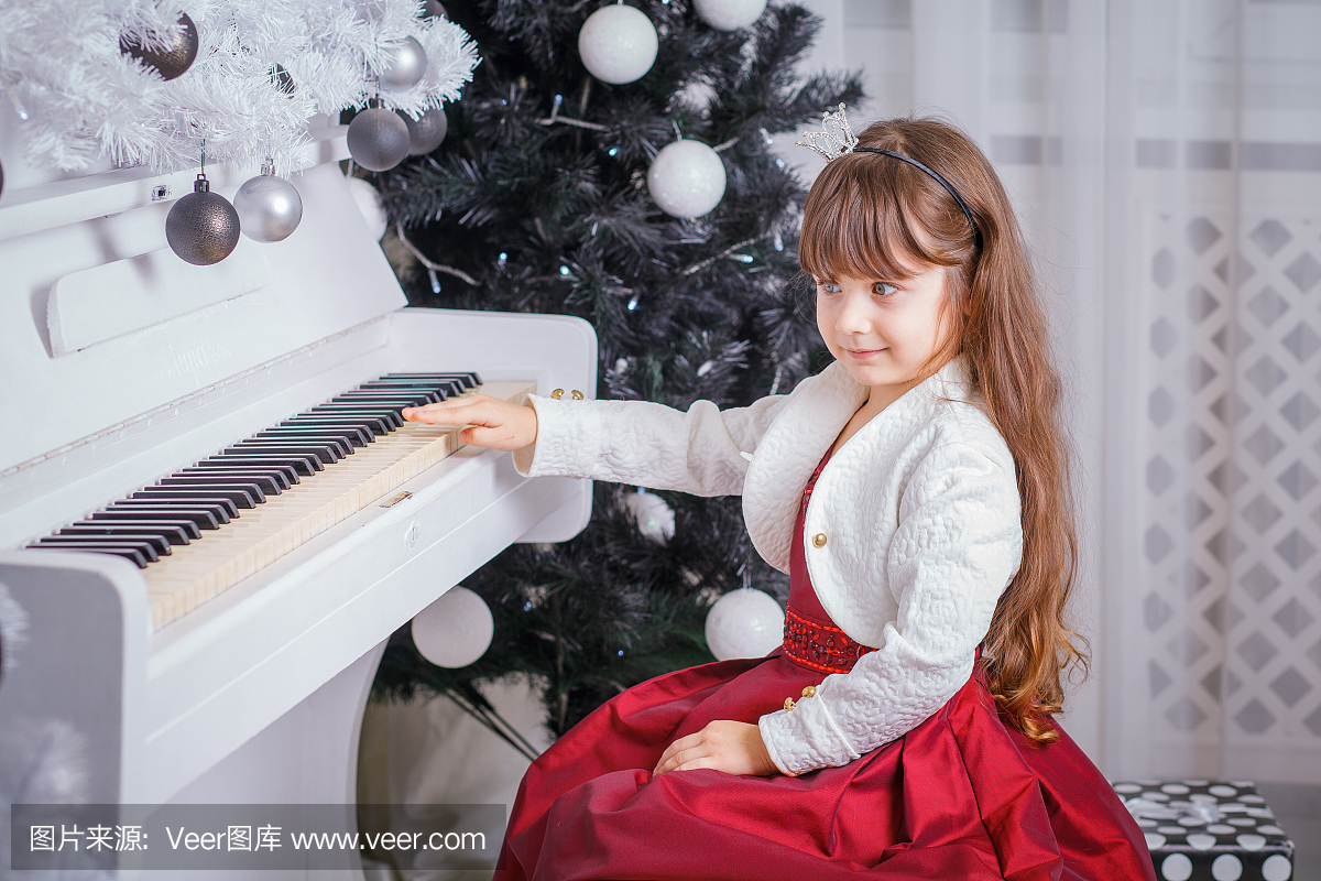 在家里弹钢琴的圣诞小孩小女孩