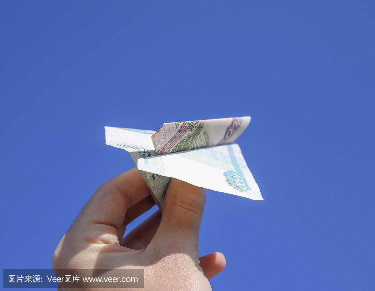 俄罗斯货币的面额,折叠在飞机上反对蓝天
