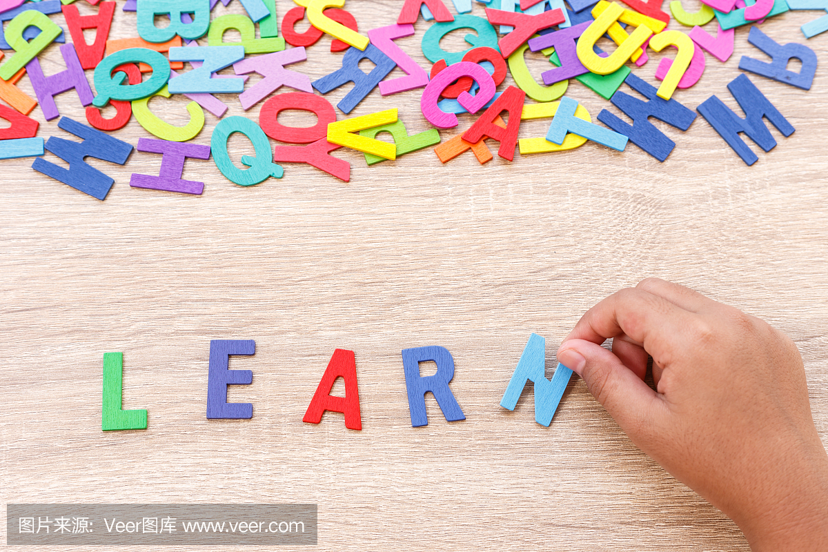 丰富多彩的木制字母表和词'学习',手排序N.在灰