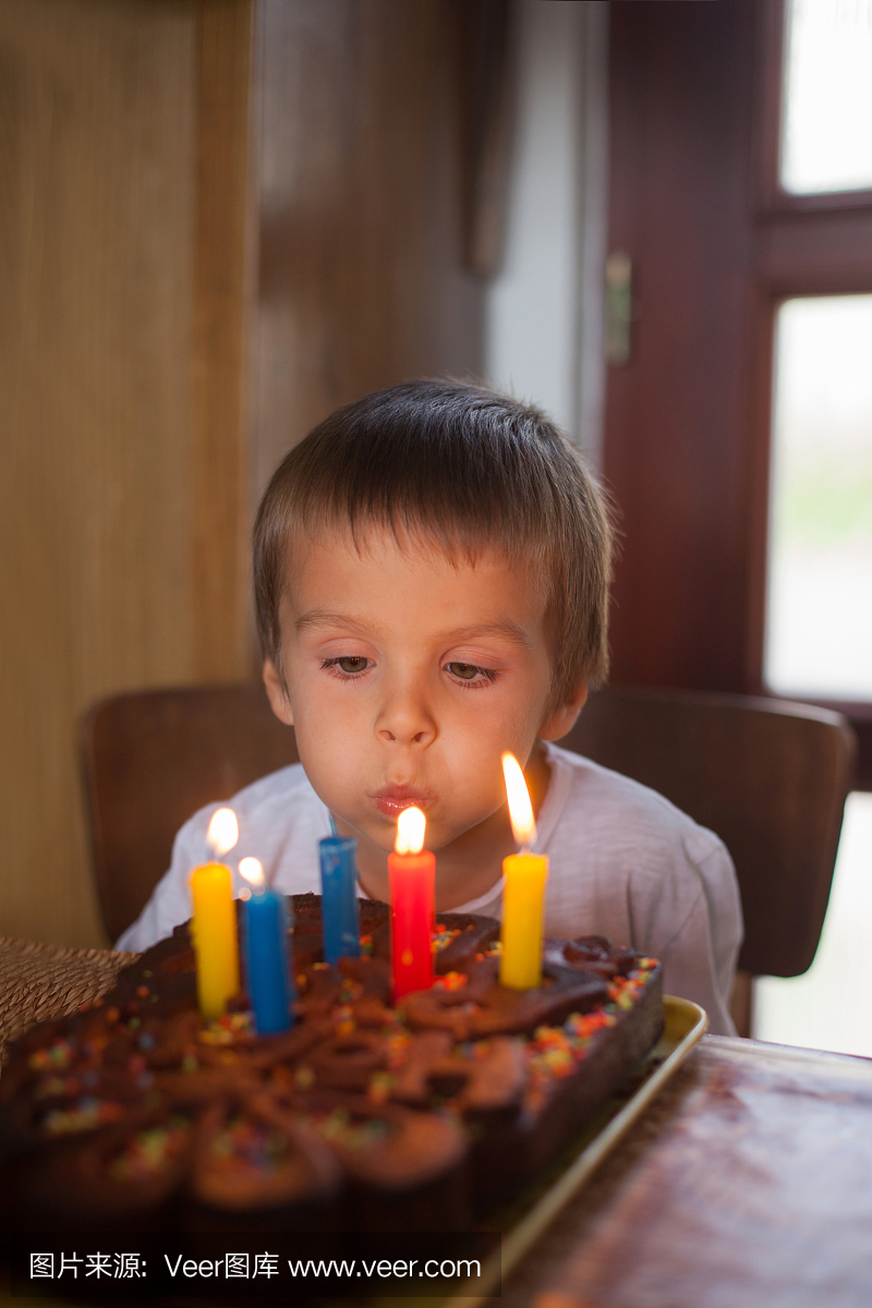可爱的五岁男孩庆祝他的生日和吹
