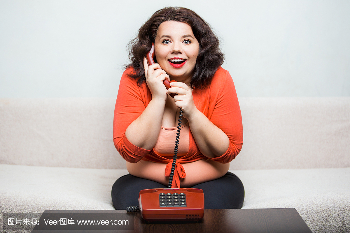 一个快乐的胖女人与电话的肖像