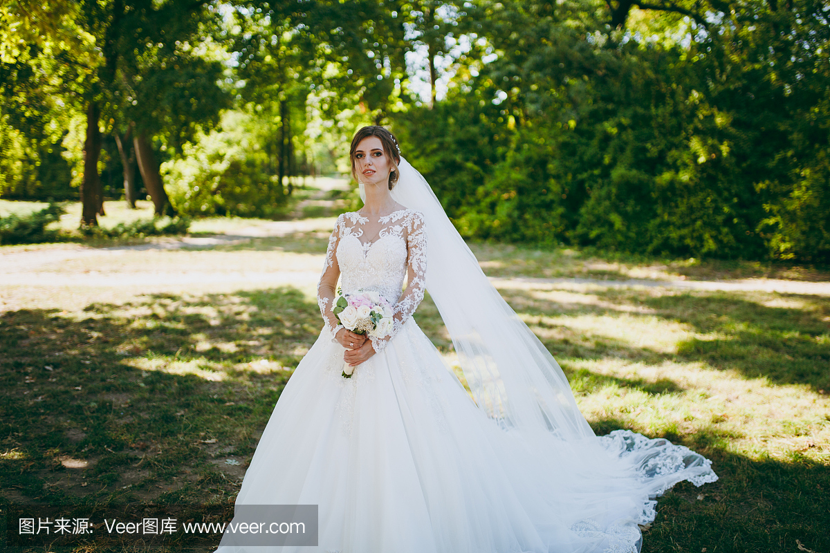 婚礼photosession。白色蕾丝礼服的新娘在长的