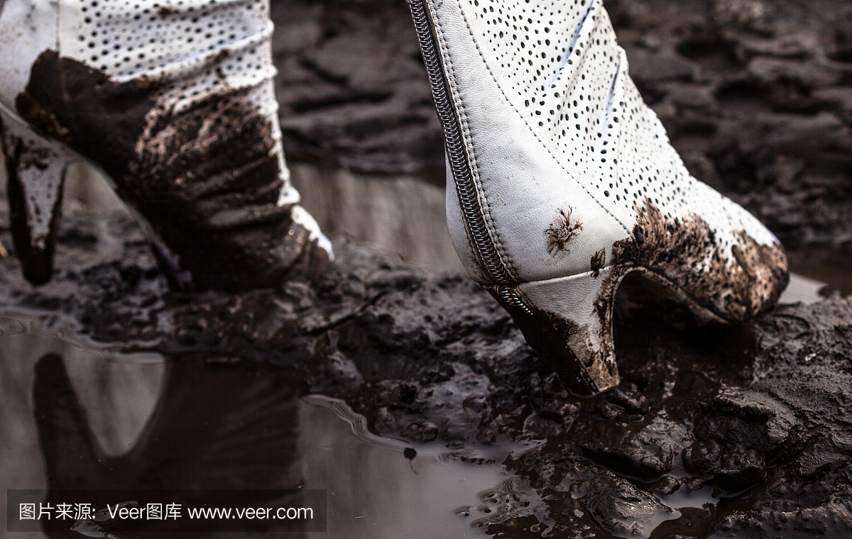 肮脏的白色高跟鞋在泥里
