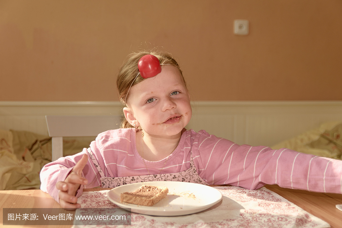 孩子吉尔吃巧克力奶油涂在面包上。巧克力甜食