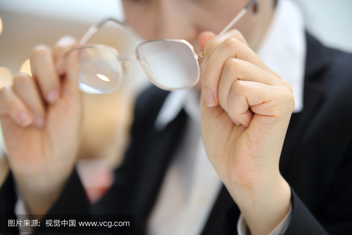 Close up of businesswoman holding eyeglasse