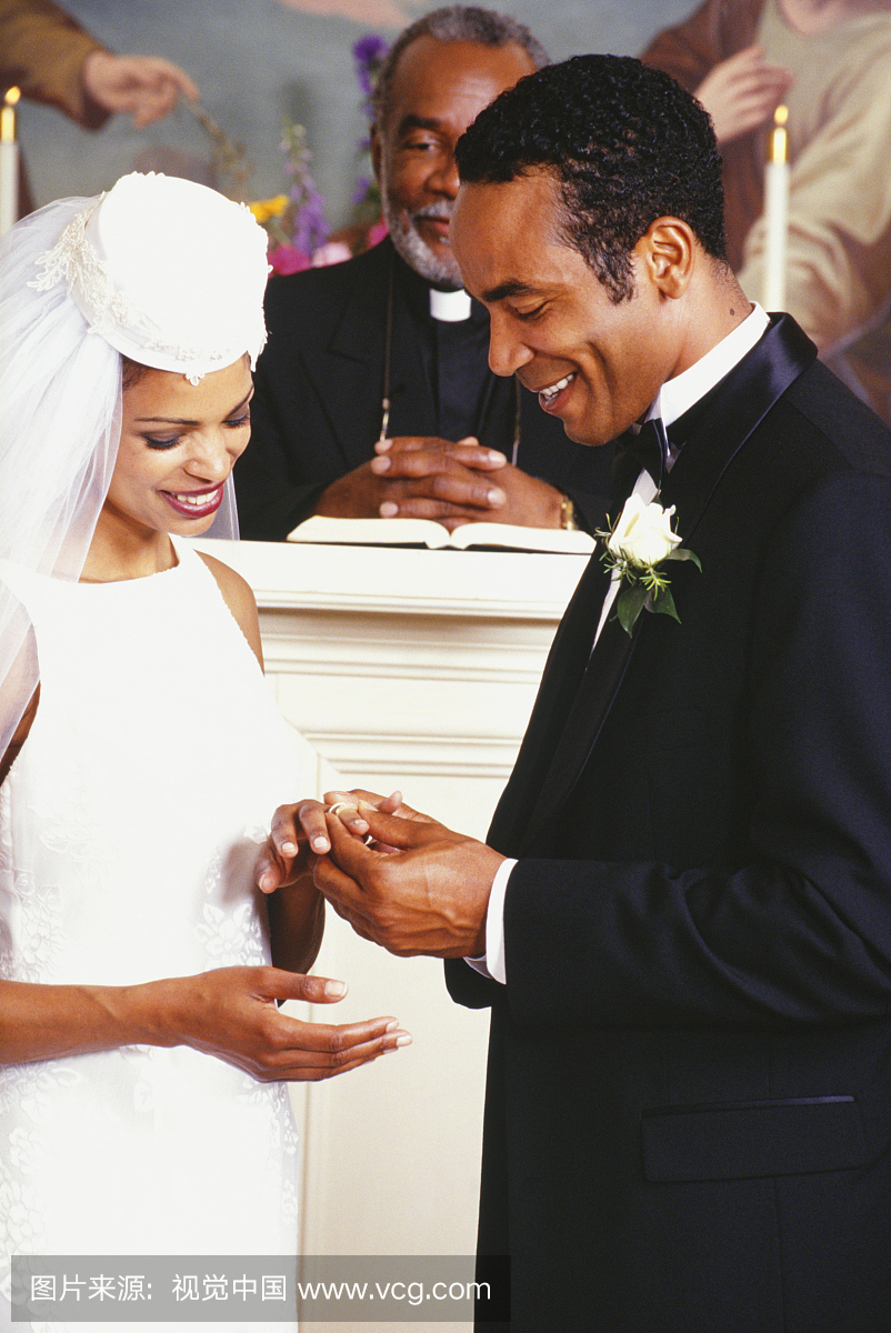新娘和新郎站在教堂里,交换结婚戒指
