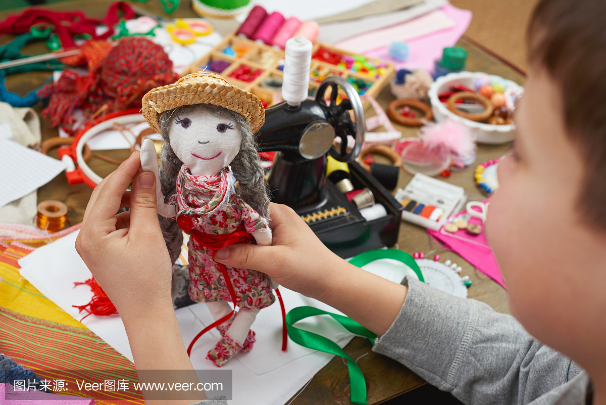 男孩裁缝学习缝纫,穿着娃娃,手工制作和工艺品