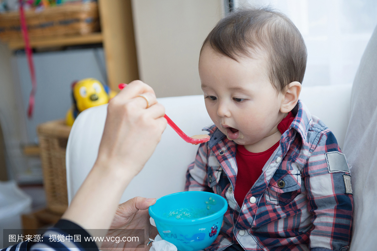 母亲用勺子喂婴儿