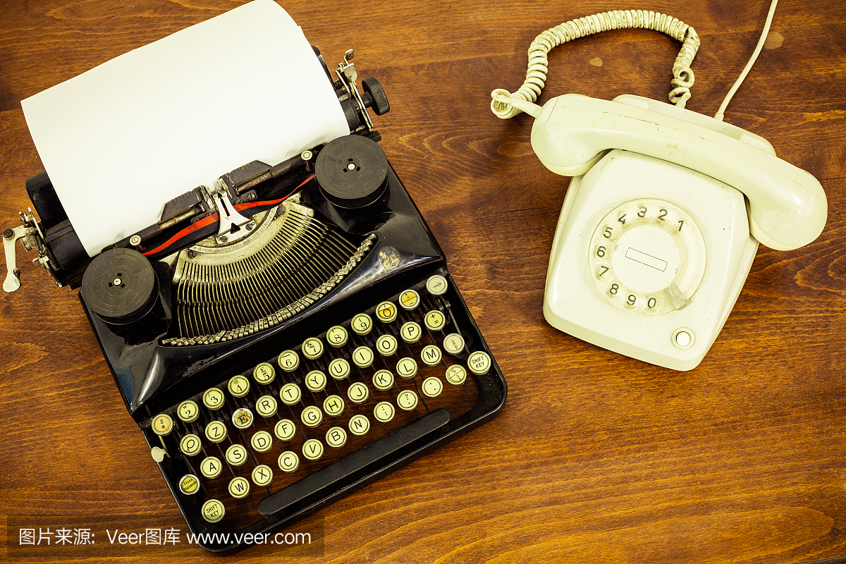 老式电话在木桌上的复古打字机