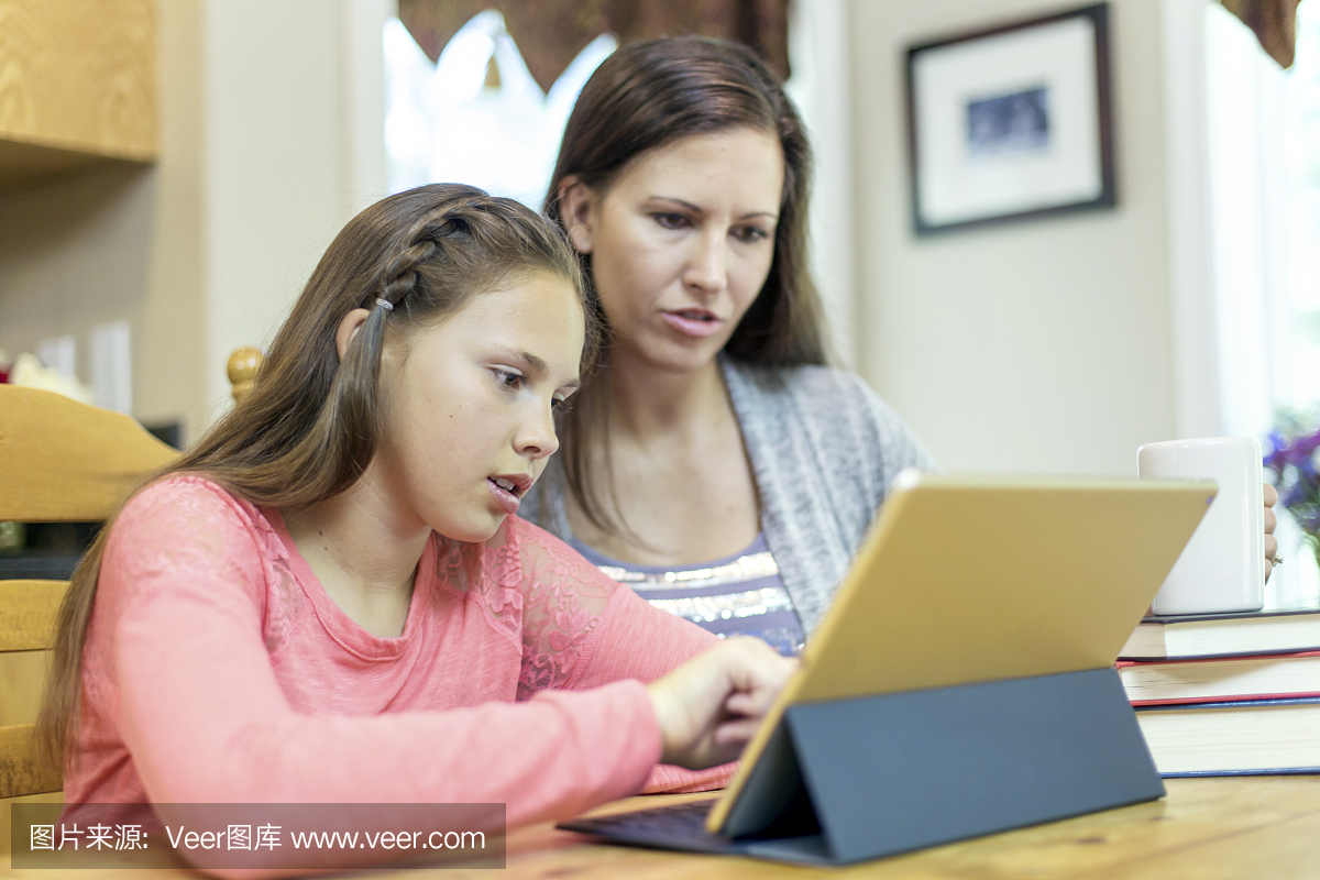 年轻女子使用智能平板电脑进行家庭作业