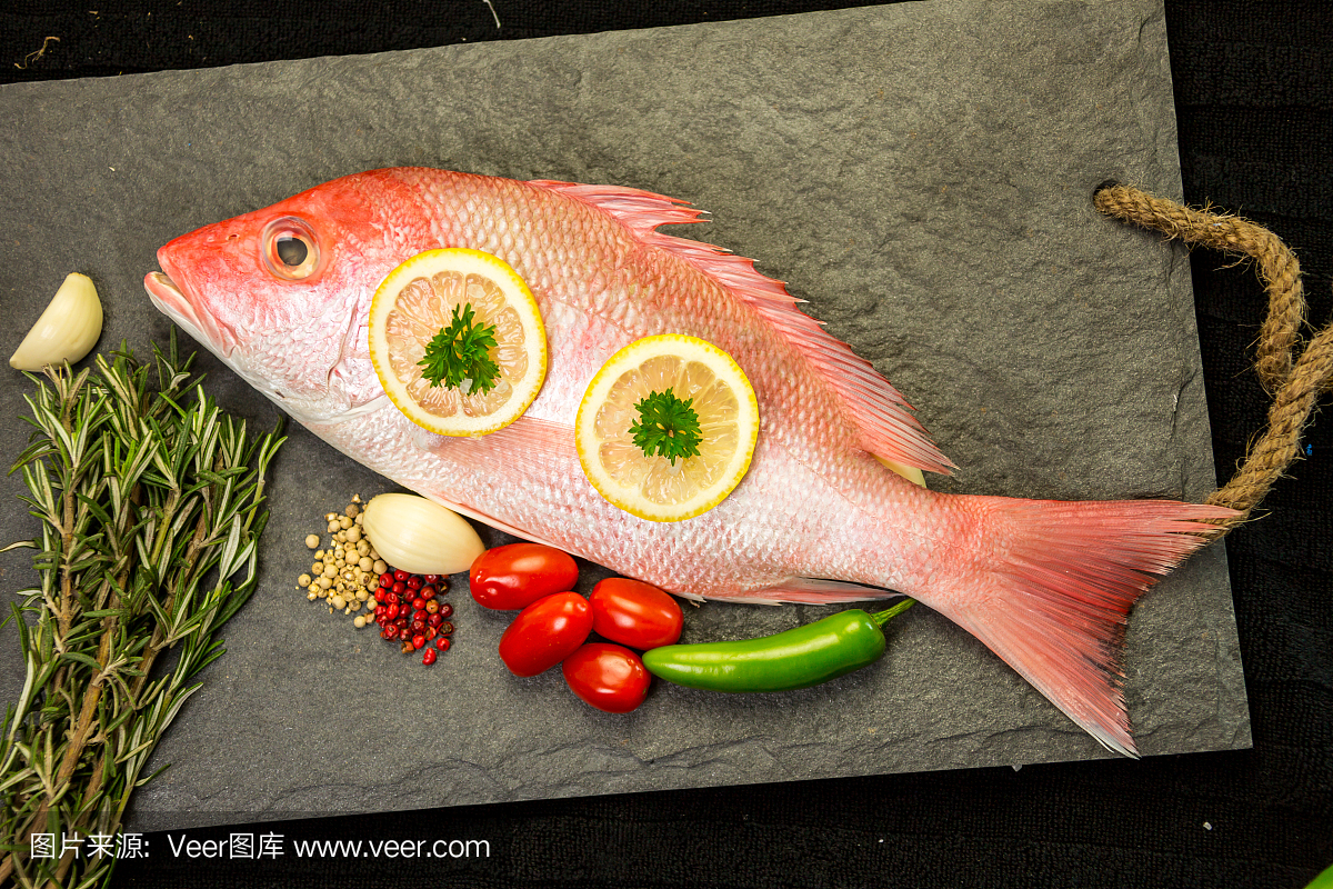 红鲷鱼与调味料和蔬菜烤架上