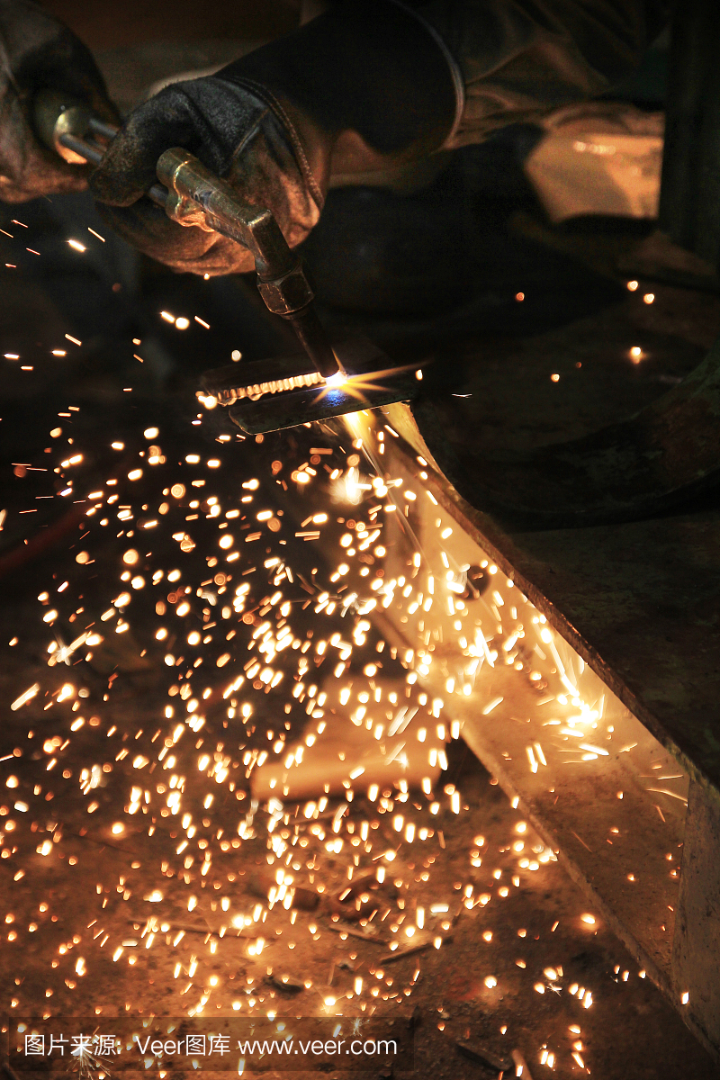 工业工人使用乙炔割炬切割钢