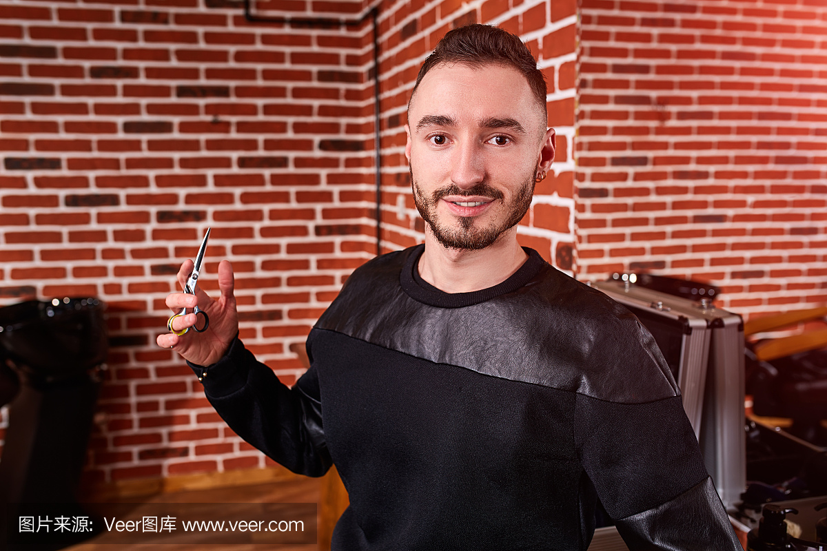 美丽的胡子美发师穿着时尚的黑色服装,在站在