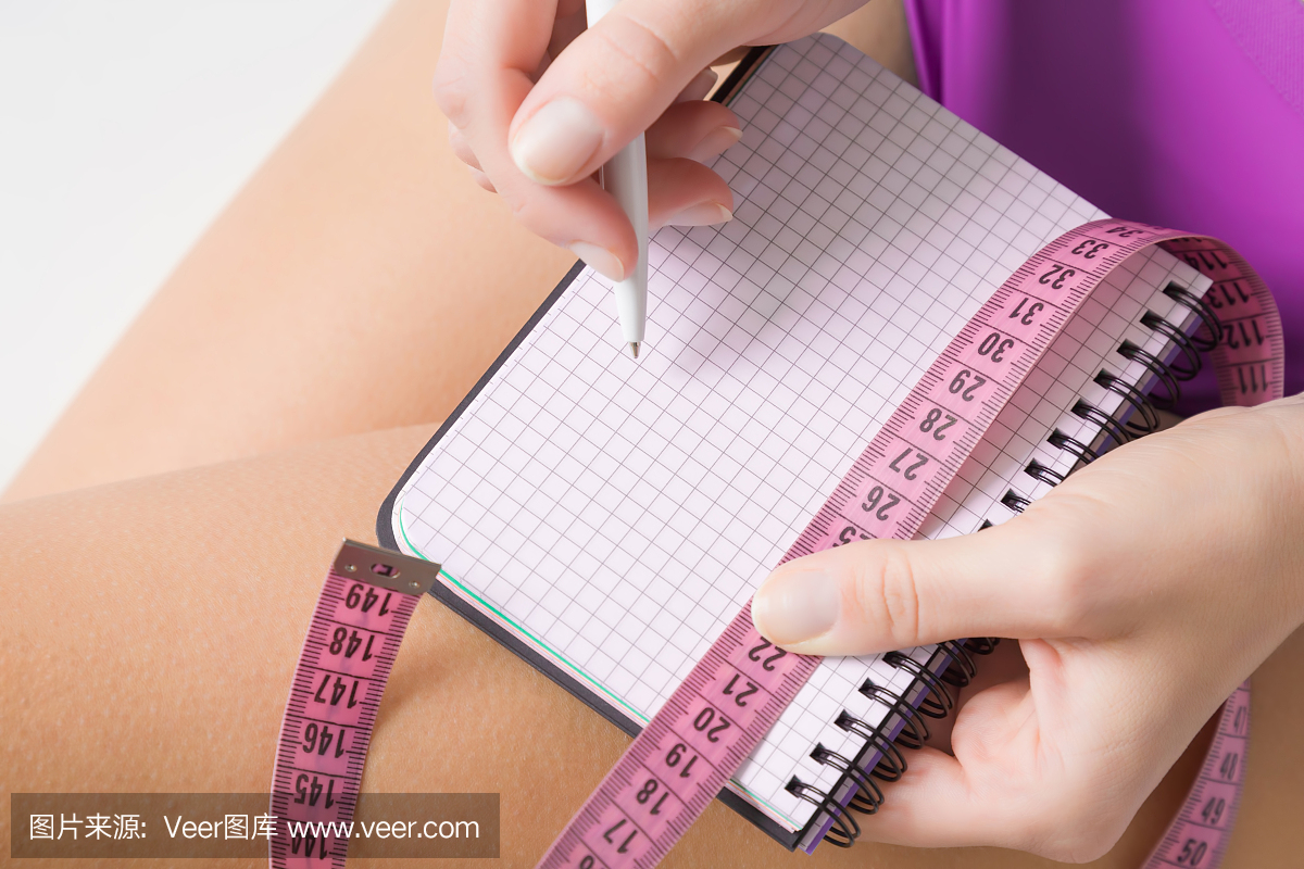 在培训之前或之后,女性在笔记本上撰写锻炼计