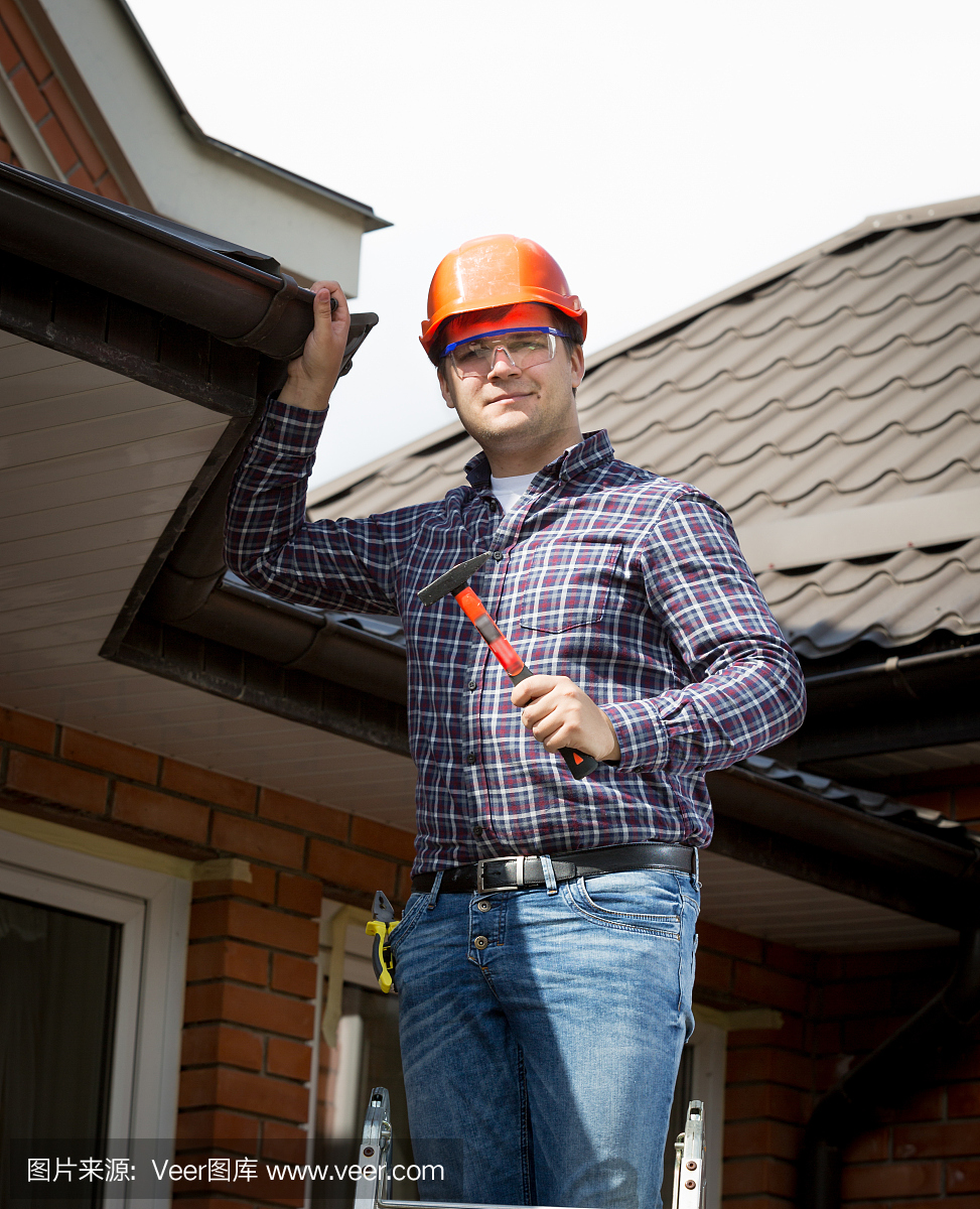 勤杂工站在高梯上,检查屋顶