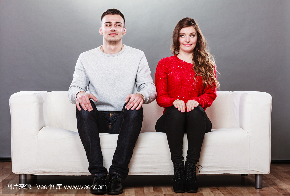 害羞的女人和男人坐在沙发上。第一次约会。