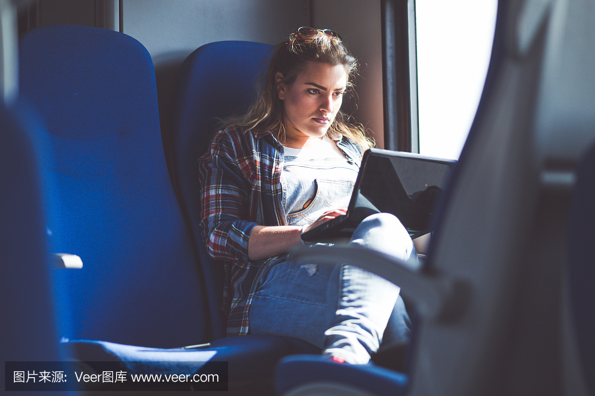 在火车上看电影的通勤女孩