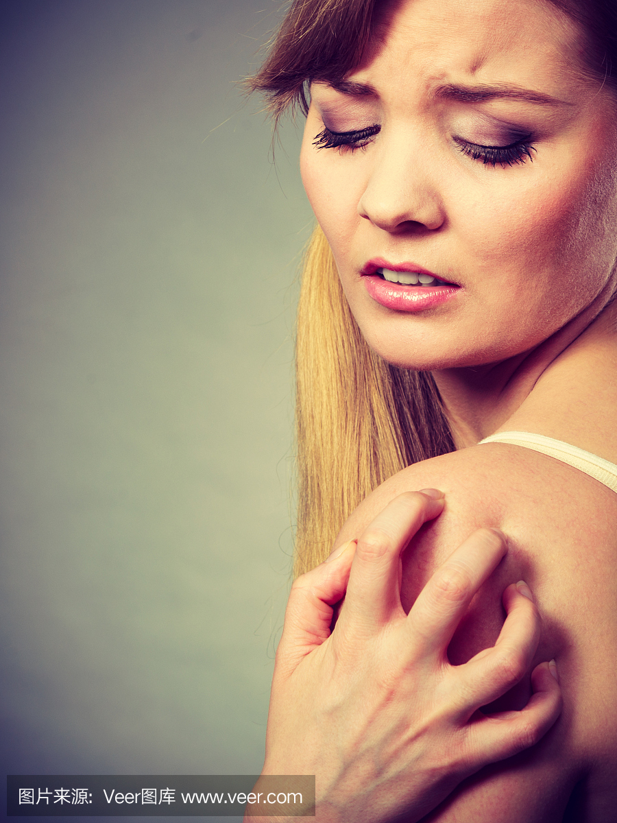 女人抓挠她的痒手臂与过敏性皮疹
