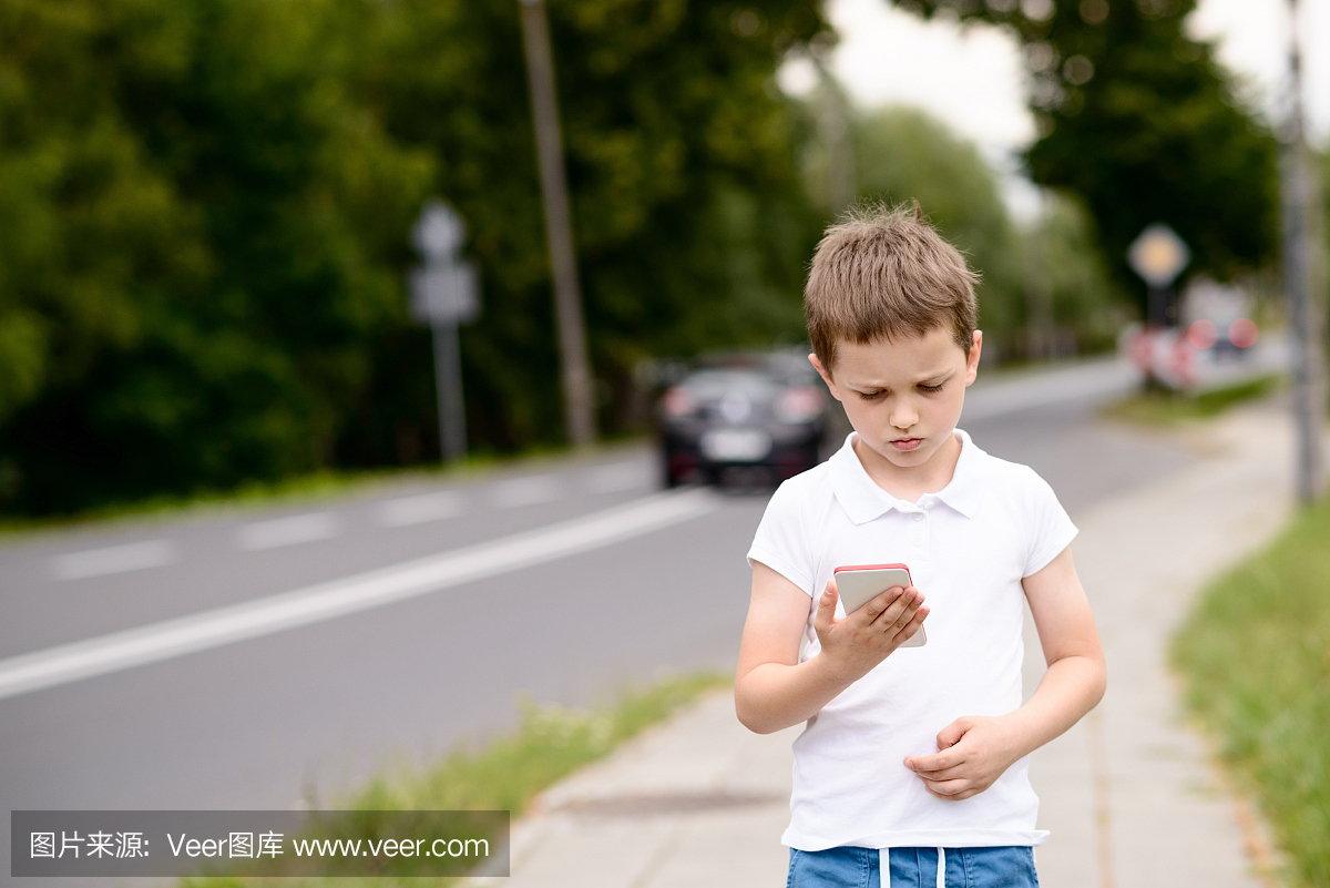 小孩在街上的智能手机上玩手机游戏