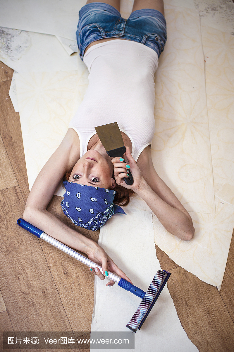 年轻美丽的女人在工具修理在房子里