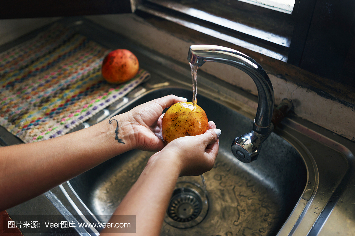 关闭女手把芒果洗到家里的厨房