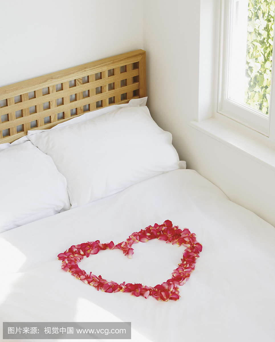 Heart of Rose Petals on a Bed