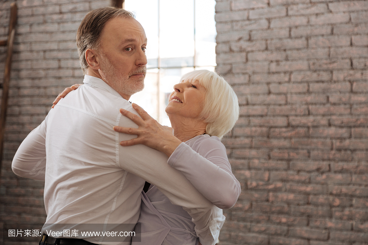 参与的舞蹈夫妇在舞蹈工作室中挥舞着