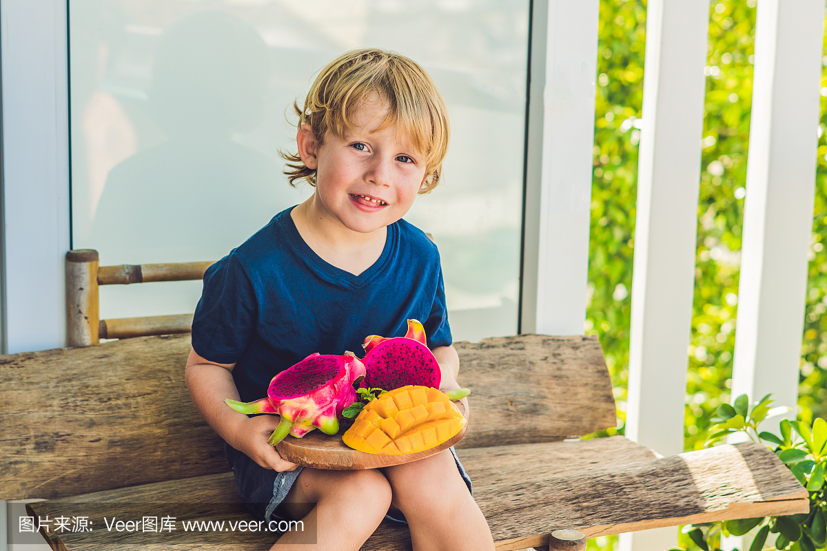 在男孩手中切丁火龙果和芒果